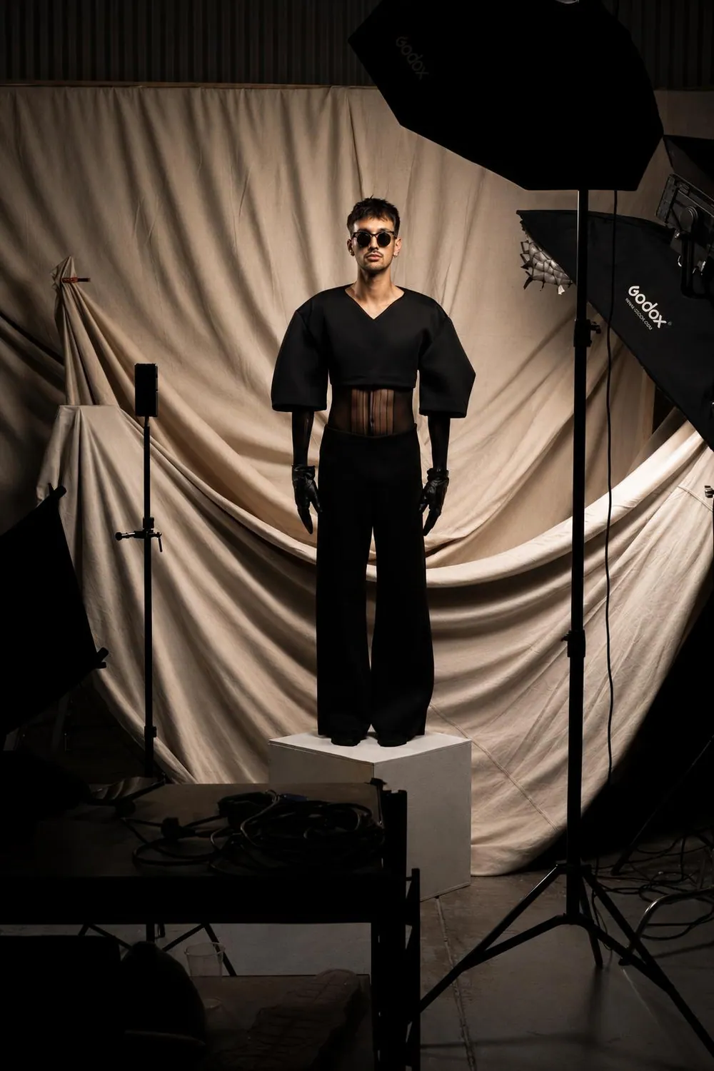 A model under studio lights on the Huxley photography set