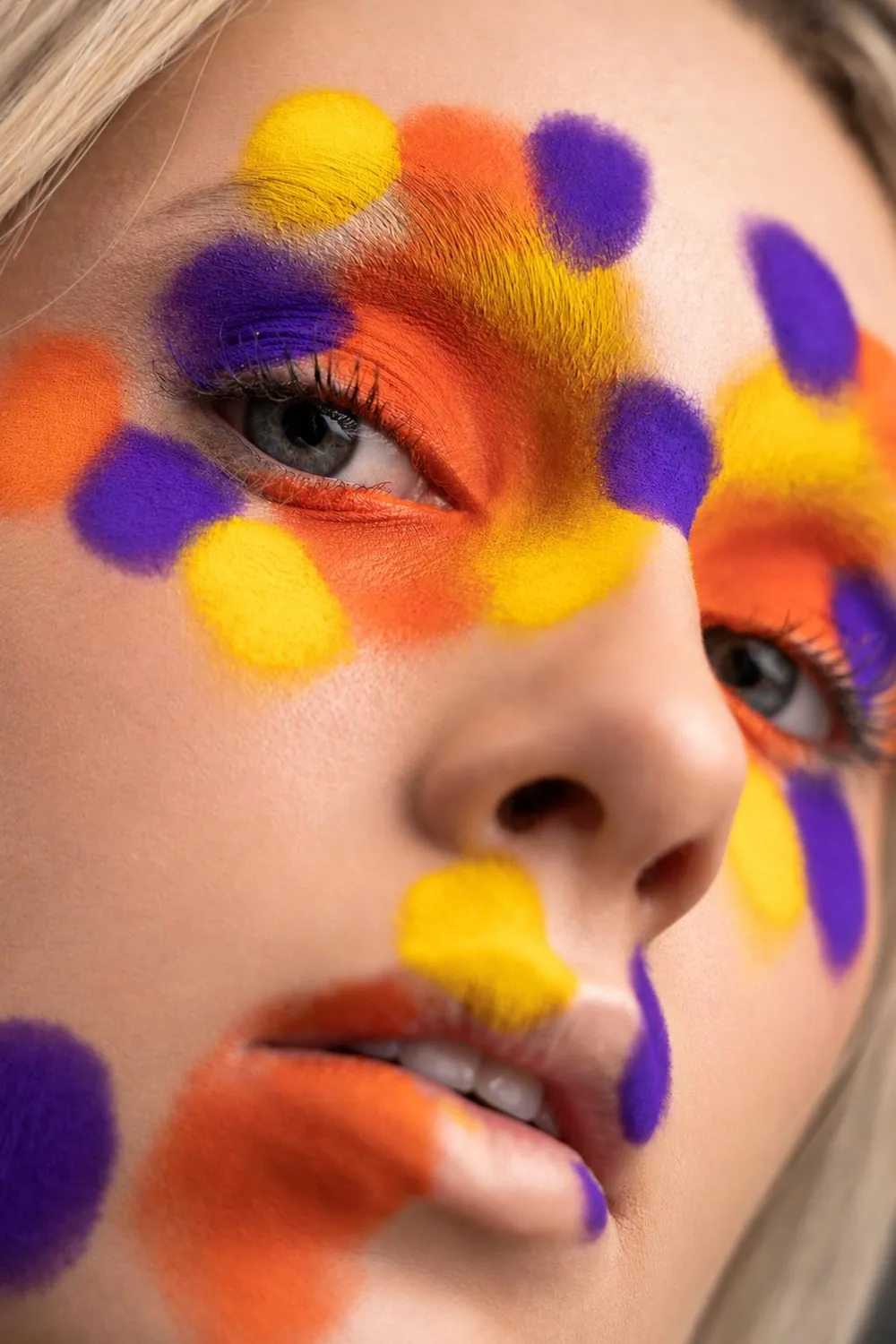 Bold creative makeup with orange, yellow and violet colour placement